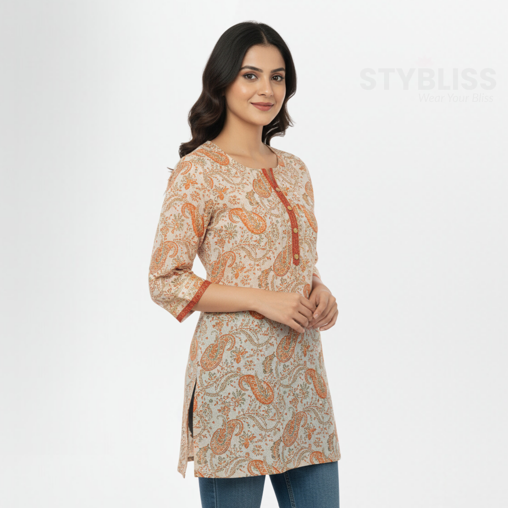 Woman wearing a patterned beige and orange top 'Stybliss' brand.